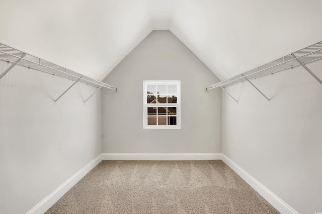 walk in closet with carpet and vaulted ceiling