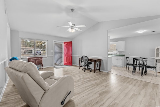 living room with ceiling fan, light hardwood / wood-style floors, and lofted ceiling