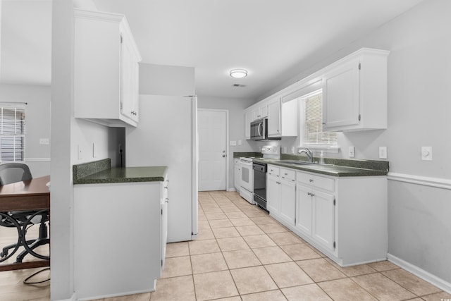 kitchen with sink, white cabinets, white appliances, and light tile patterned floors