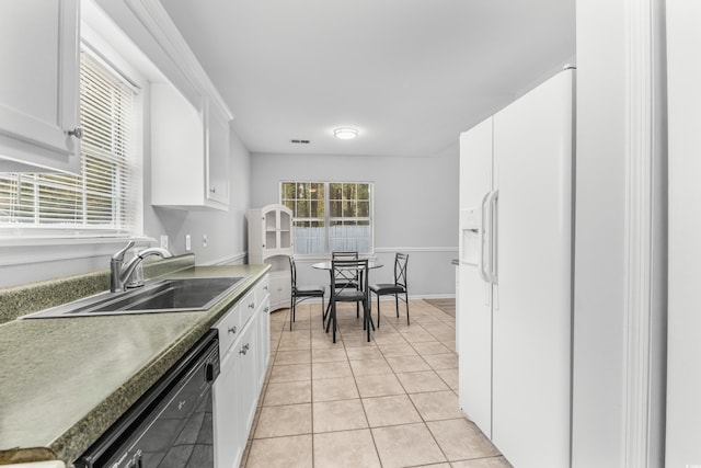 kitchen with dishwasher, sink, white cabinets, and light tile patterned floors