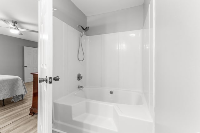 bathroom with hardwood / wood-style floors, shower / washtub combination, and ceiling fan