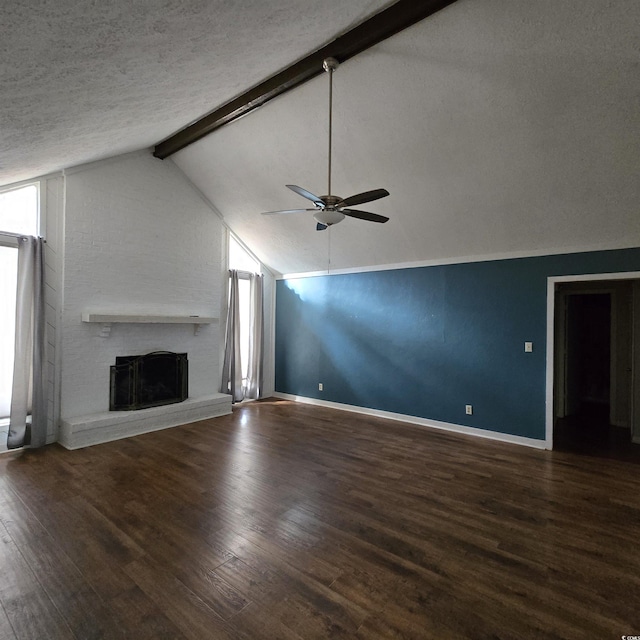 unfurnished living room featuring lofted ceiling with beams, a brick fireplace, ceiling fan, a textured ceiling, and dark hardwood / wood-style flooring