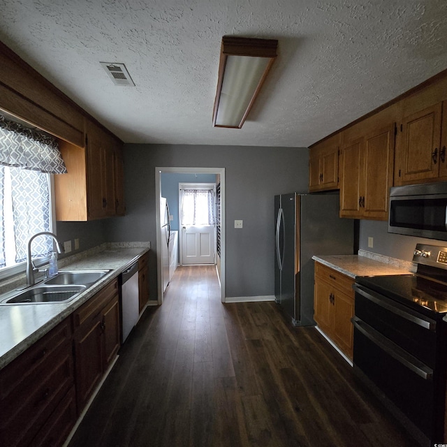 kitchen featuring dark hardwood / wood-style flooring, sink, a textured ceiling, and appliances with stainless steel finishes