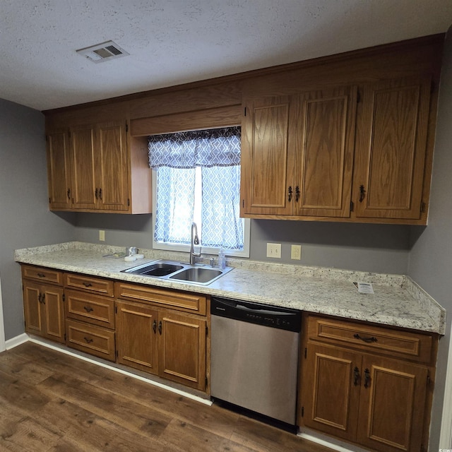 kitchen with a textured ceiling, stainless steel dishwasher, dark wood-type flooring, and sink