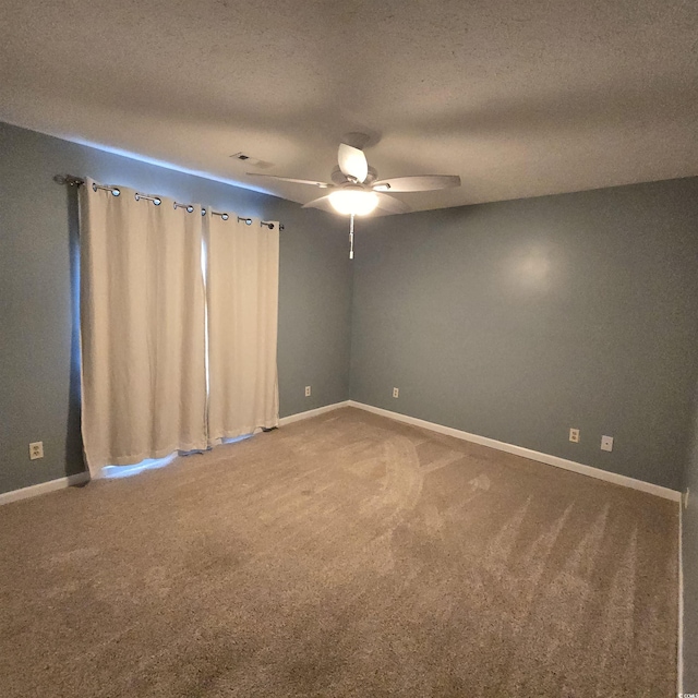 spare room with a textured ceiling, carpet floors, and ceiling fan