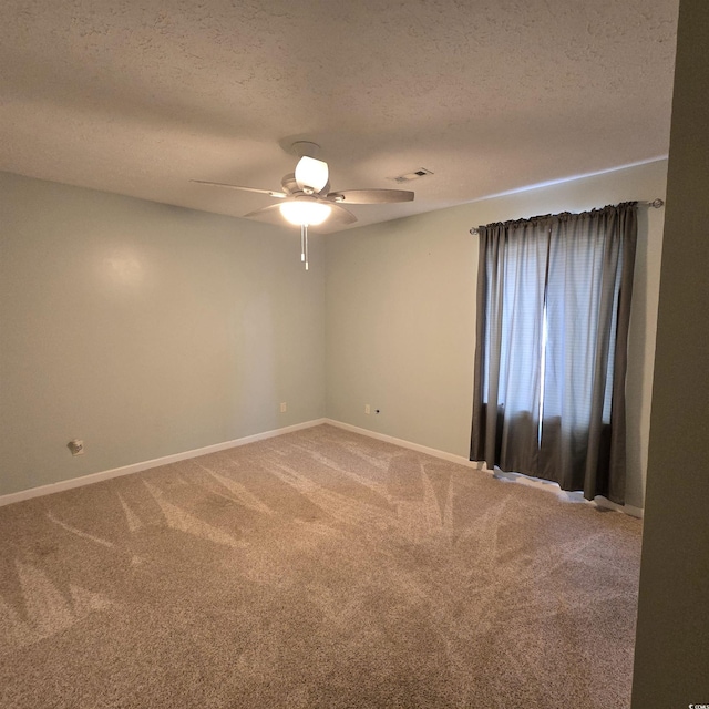 empty room with carpet flooring, a textured ceiling, and ceiling fan