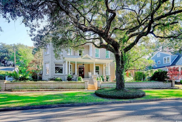 view of front of home with covered porch and a front yard