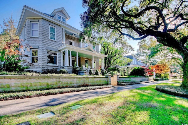 view of front facade featuring a front lawn and covered porch