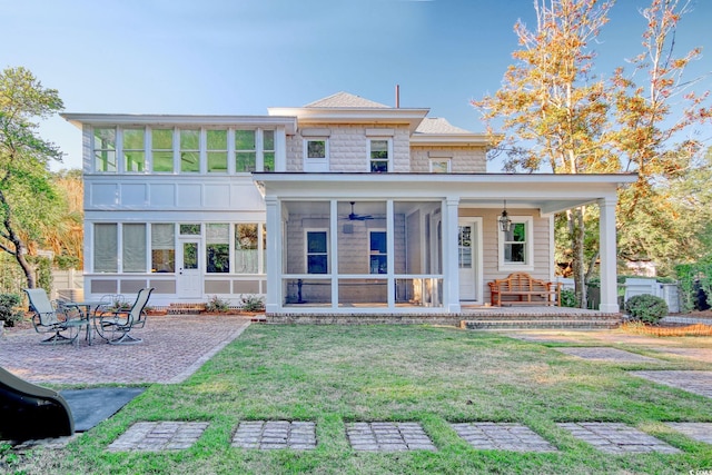 back of property featuring a lawn and a sunroom