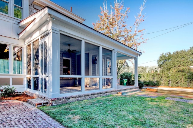 view of home's exterior featuring a sunroom and a yard