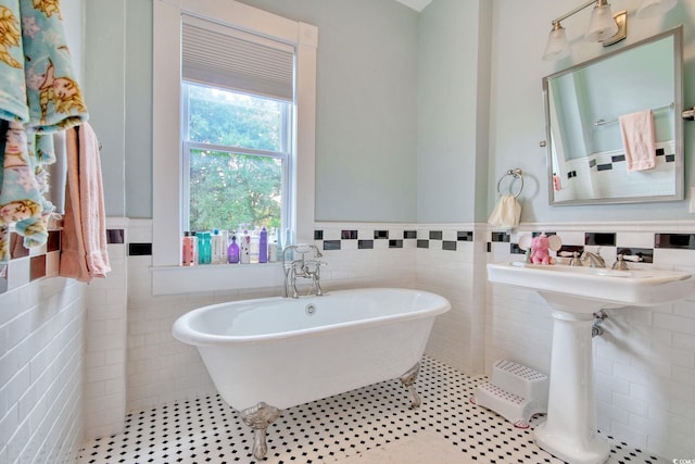 bathroom featuring tile patterned flooring, a bath, and tile walls