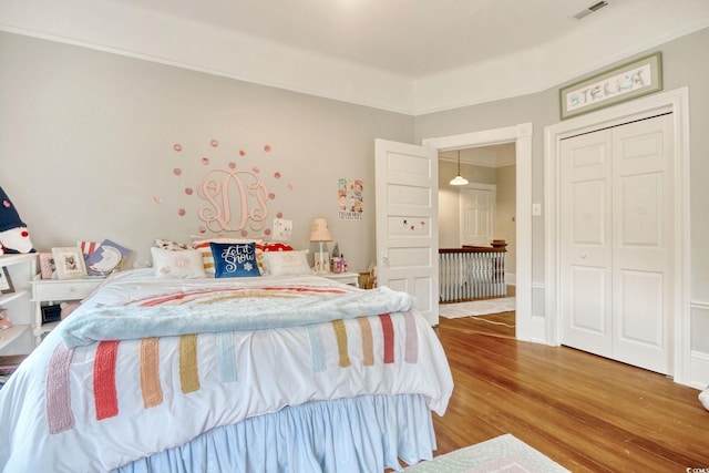 bedroom with hardwood / wood-style floors and a closet