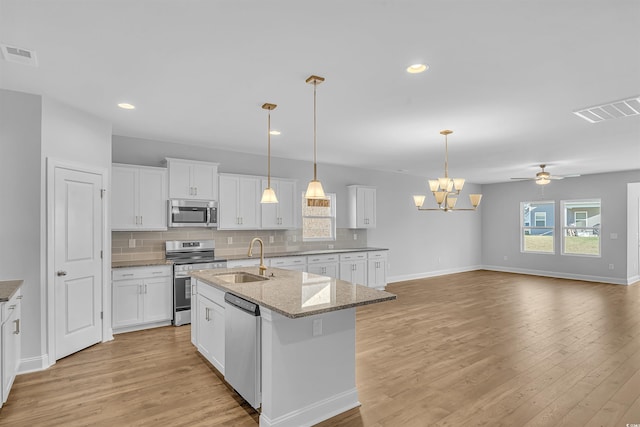 kitchen with a sink, stainless steel appliances, backsplash, and visible vents