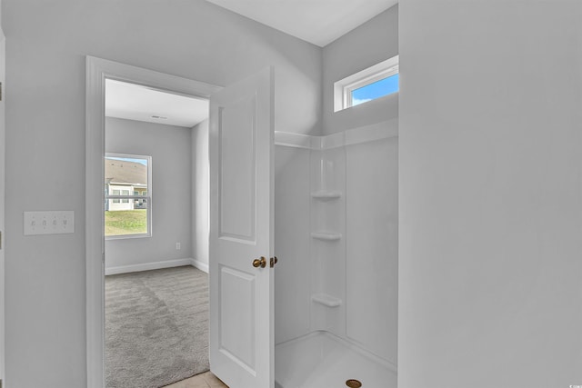 bathroom featuring baseboards and walk in shower