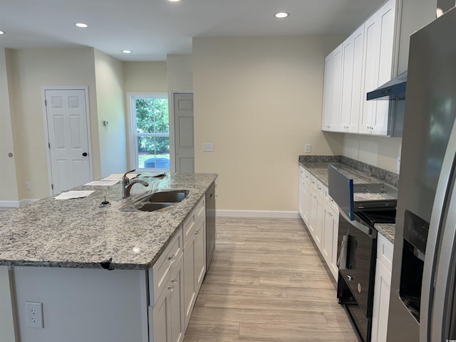 kitchen featuring stainless steel appliances, a kitchen island with sink, sink, white cabinets, and light hardwood / wood-style floors