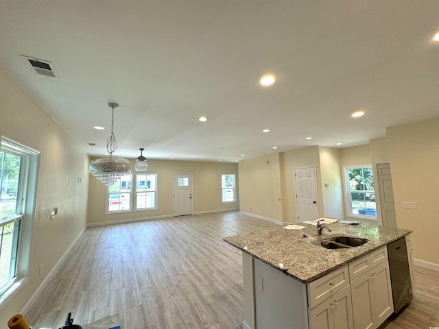 kitchen with sink, a center island with sink, light hardwood / wood-style flooring, dishwasher, and white cabinetry