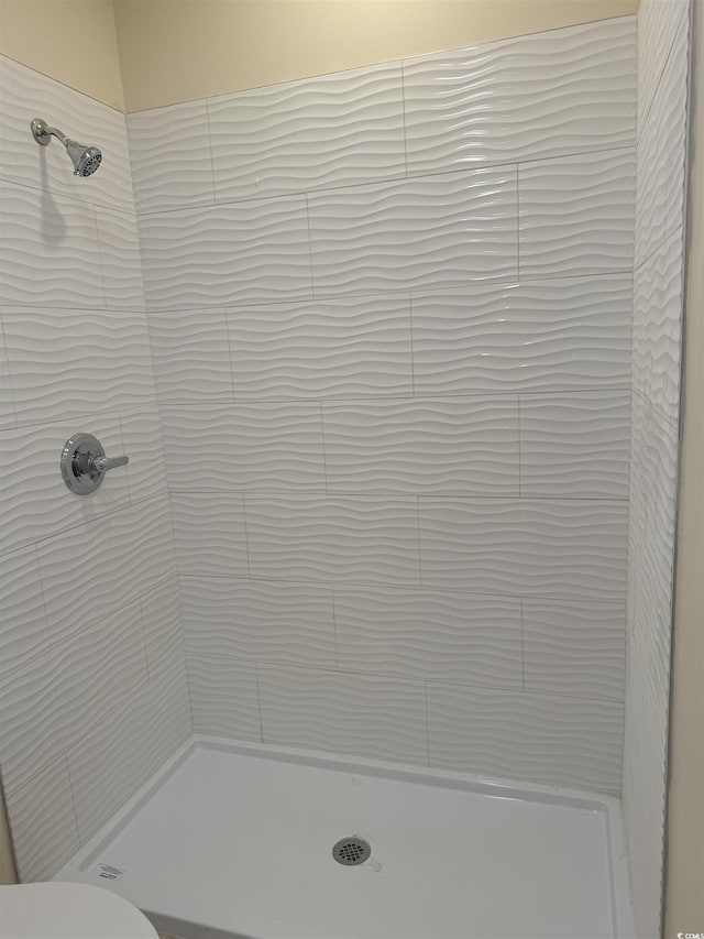 bathroom featuring toilet and tiled shower