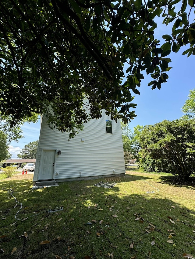 view of side of home with a yard