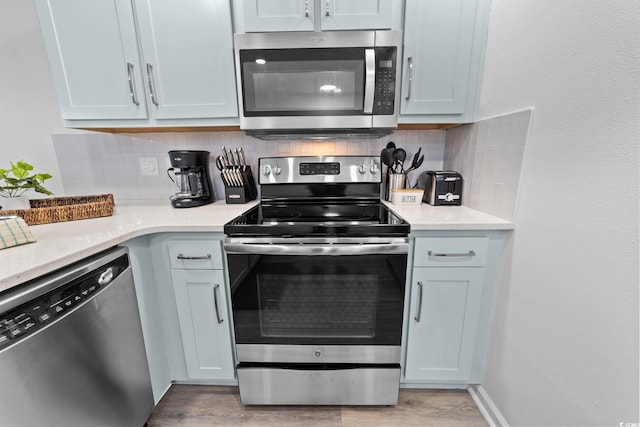 kitchen featuring light hardwood / wood-style floors, stainless steel appliances, and tasteful backsplash