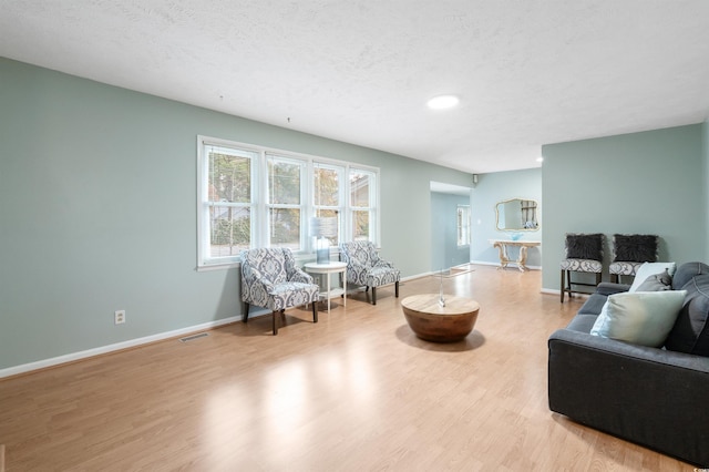 living room featuring light hardwood / wood-style flooring and a textured ceiling