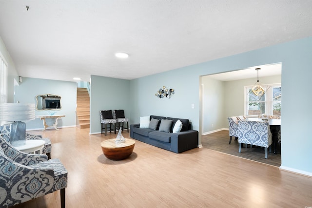 living room with hardwood / wood-style flooring and a notable chandelier