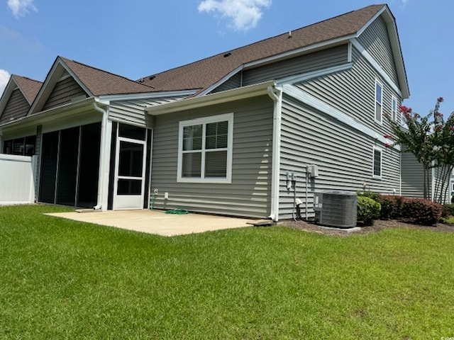 back of house with central AC unit, a patio area, and a yard