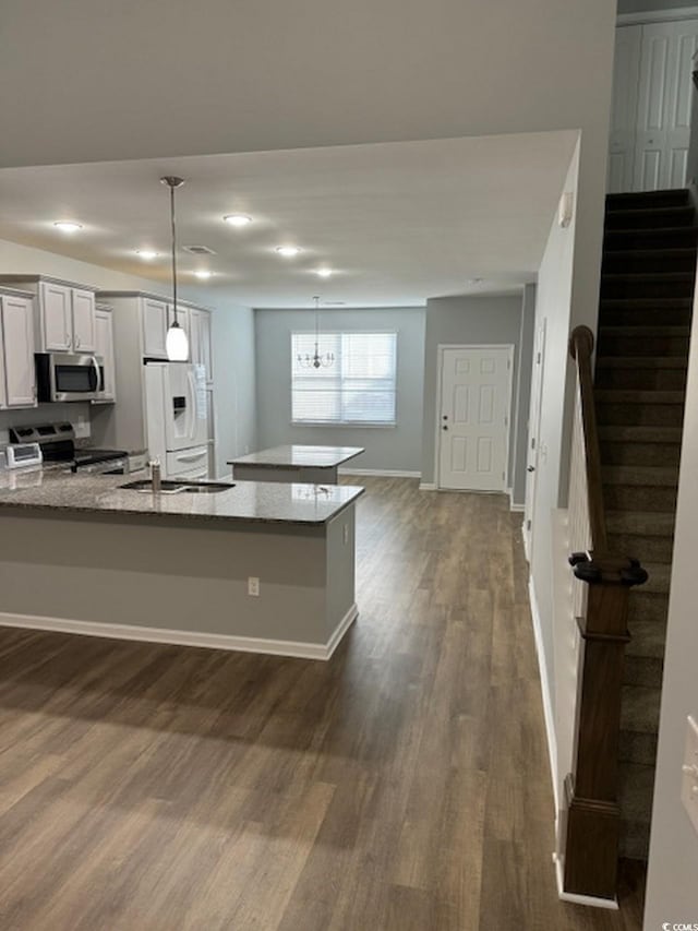 kitchen with white cabinetry, sink, dark hardwood / wood-style floors, pendant lighting, and appliances with stainless steel finishes