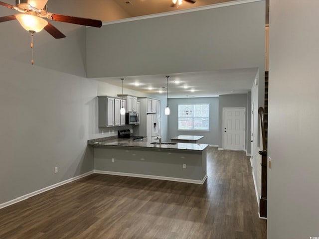 kitchen with kitchen peninsula, electric range, ceiling fan, and dark wood-type flooring