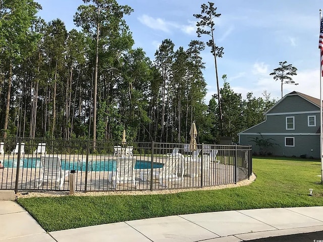 view of pool featuring a patio area and a yard