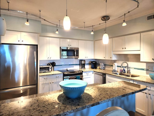 kitchen with white cabinets, appliances with stainless steel finishes, hanging light fixtures, and sink