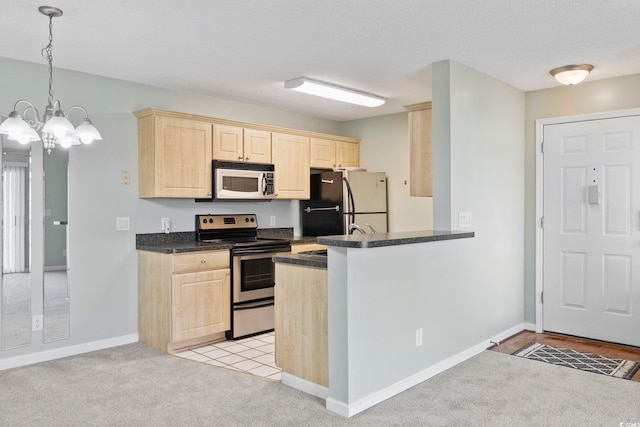 8830 Chandler Dr Unit E, Myrtle Beach, SC 29575 - kitchen with stainless steel electric range, light brown cabinets, freestanding refrigerator, dark countertops, and a chandelier