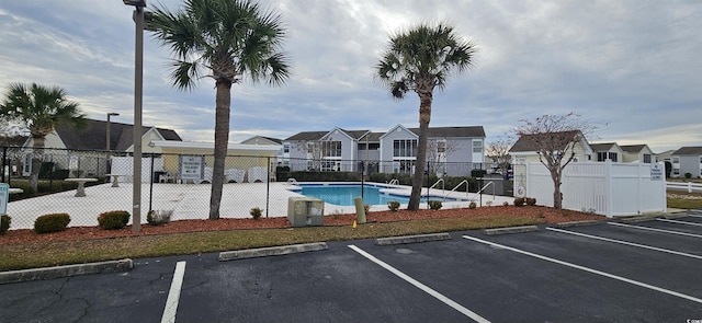 8830 Chandler Dr Unit E, Myrtle Beach, SC 29575 - uncovered parking lot featuring a residential view, fence, and a community pool