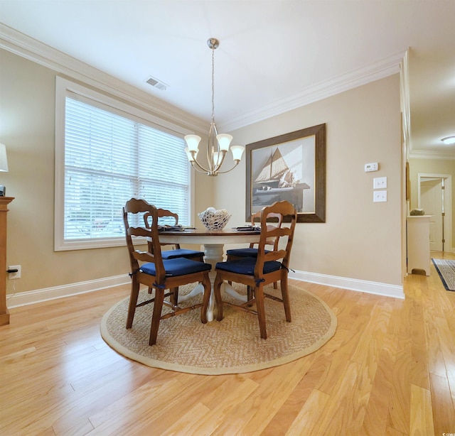 dining area featuring a notable chandelier, light hardwood / wood-style floors, and ornamental molding