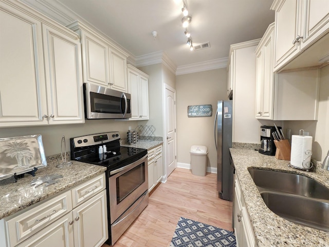 kitchen with crown molding, sink, light hardwood / wood-style flooring, light stone countertops, and appliances with stainless steel finishes