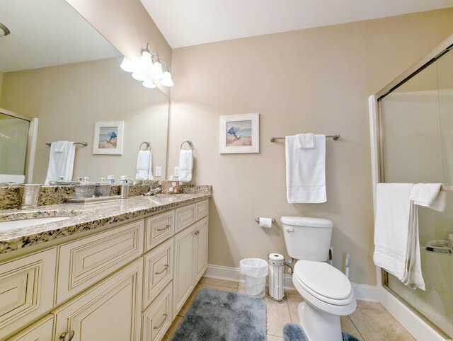 bathroom featuring tile patterned flooring, vanity, toilet, and walk in shower