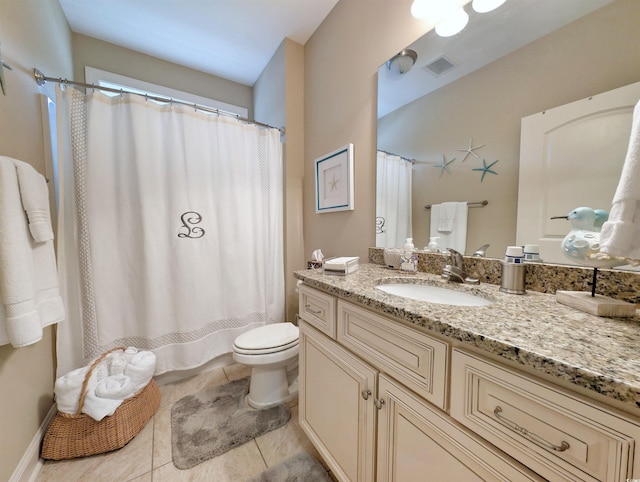 bathroom with tile patterned flooring, vanity, and toilet