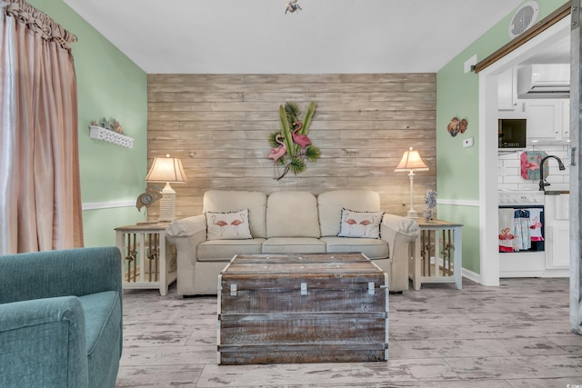 living room featuring wooden walls and a wall mounted AC