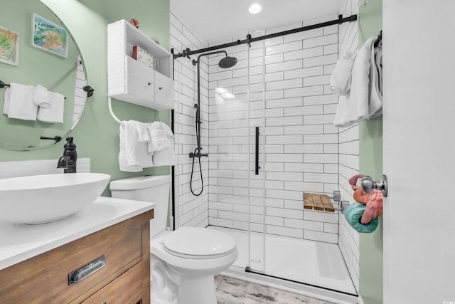 bathroom featuring an enclosed shower, vanity, toilet, and wood-type flooring