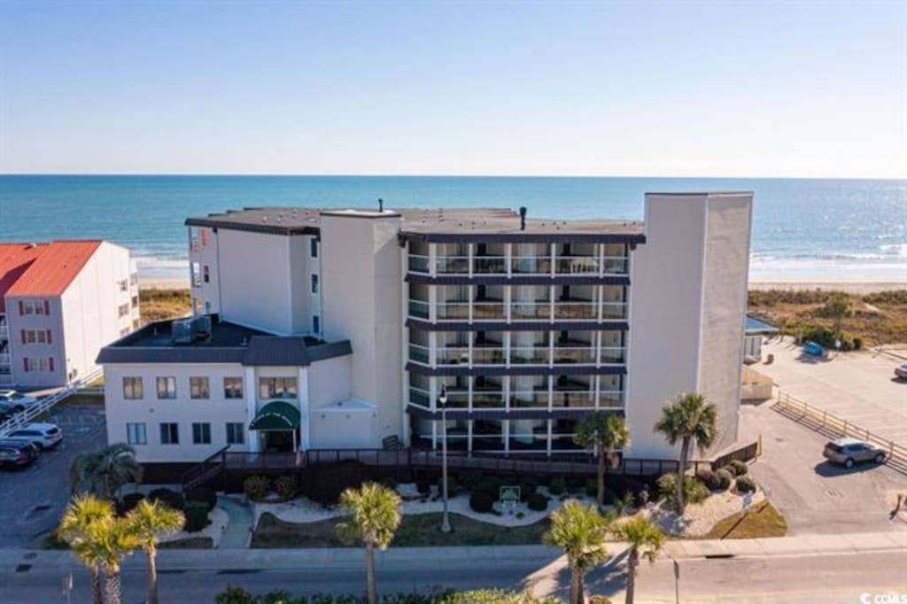 view of property with a water view and a beach view