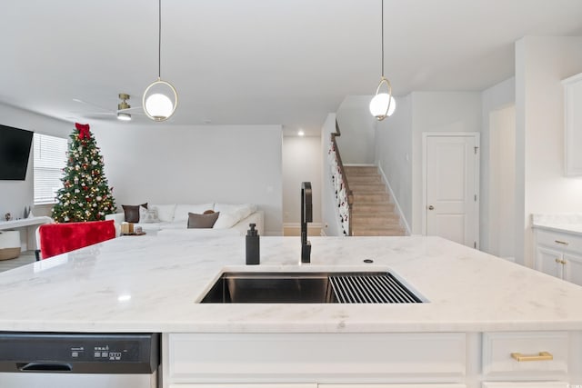 kitchen featuring hanging light fixtures, white cabinets, stainless steel dishwasher, and hardwood / wood-style flooring