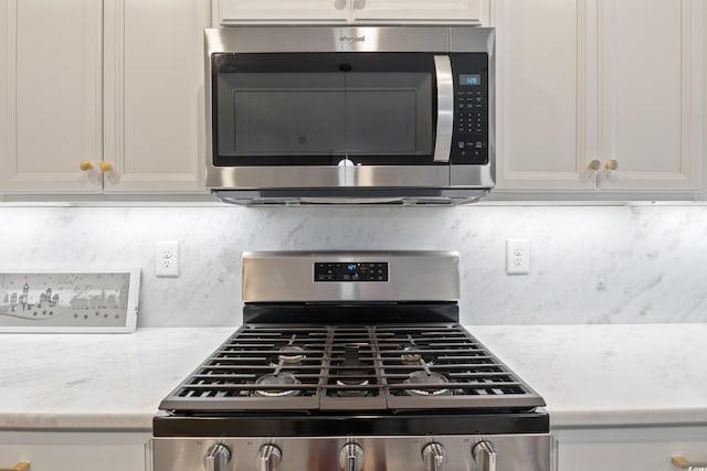 kitchen featuring light stone counters, white cabinetry, and appliances with stainless steel finishes