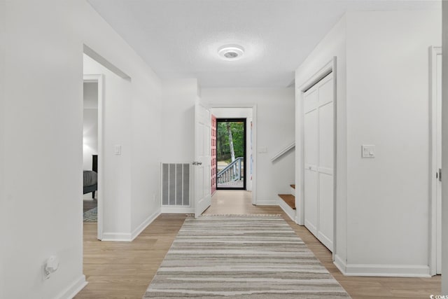 interior space with a textured ceiling and light wood-type flooring