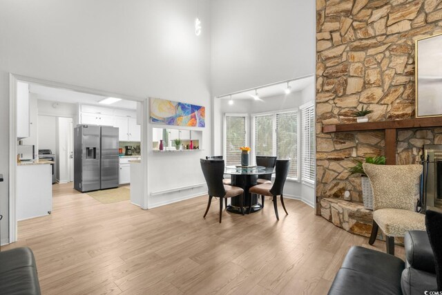 dining space with light hardwood / wood-style flooring and track lighting