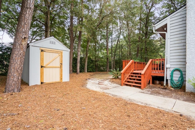 view of yard featuring a storage unit and a wooden deck