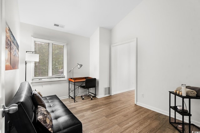 living area featuring vaulted ceiling and hardwood / wood-style flooring