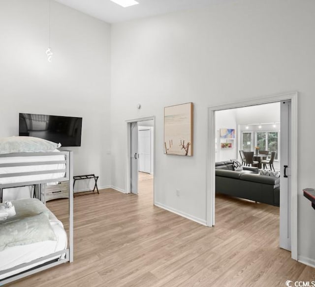 bedroom featuring a high ceiling and light hardwood / wood-style flooring