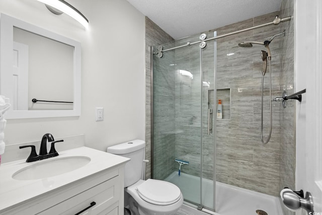 bathroom with vanity, an enclosed shower, a textured ceiling, and toilet