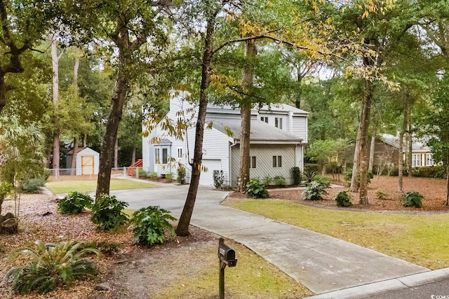 view of front of property with a garage, a shed, and a front lawn