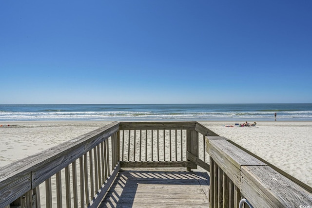 view of community featuring a water view and a beach view