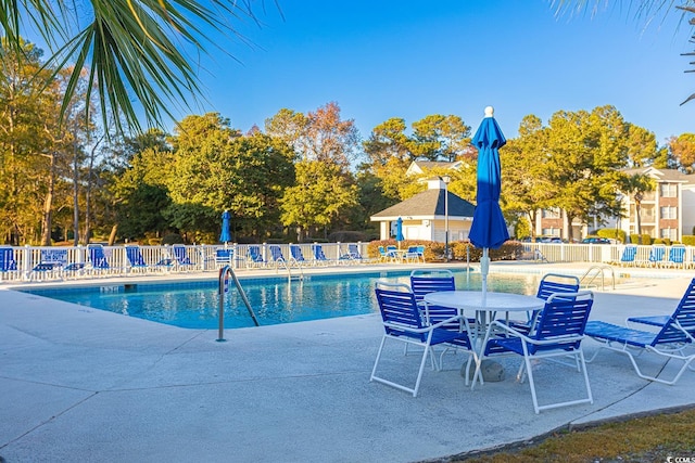 pool featuring fence and a patio